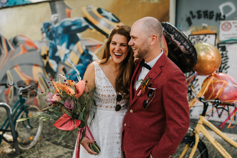 Lockere Hochzeitsfotos Sektempfang Brautpaar mit Tandem Fahrrad