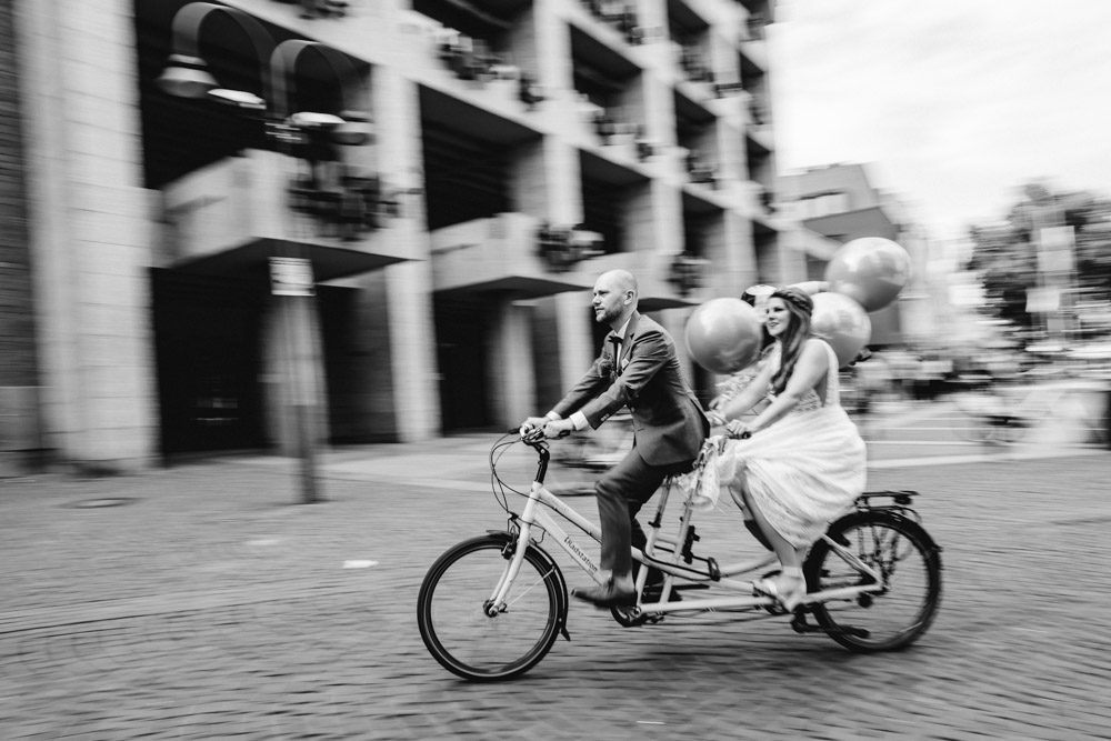 Lockere Hochzeitsfotos Sektempfang Brautpaar mit Tandem Fahrrad