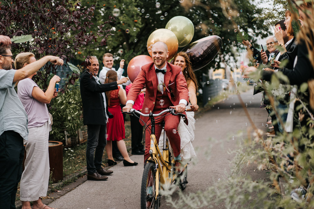 Lockere Hochzeitsfotos Sektempfang Brautpaar mit Tandem Fahrrad